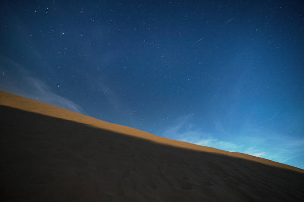 istock Scenic view of dune with magic starry sky above it 1454971738