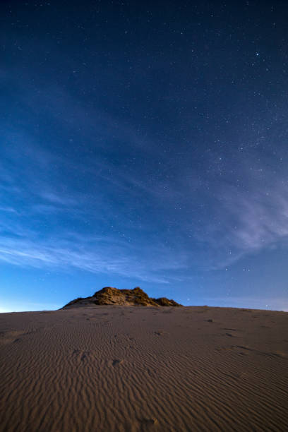 istock Vertical shot of a desert dune on a beautiful starry night sky 1454971751