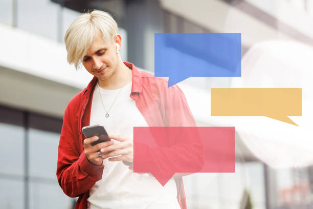 istock Young hipster communicating online with illustrations of conversation blocks in the foreground 1454971771