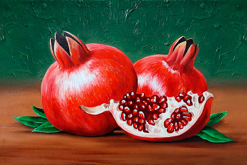 An oil painting depicting a still life of whole and half pomegranates
