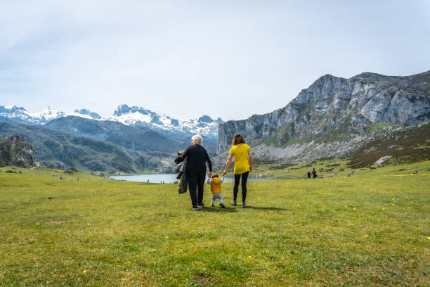 immagine posteriore di una famiglia di tre generazioni che visita il lago ercina, i laghi di covadonga, asturie, spagna - covadonga foto e immagini stock