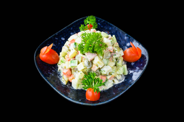 istock Russian salad olivie on black background side view 1454973434
