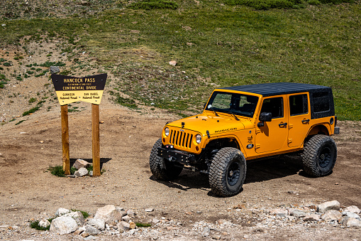St Elmo, United States – July 09, 2021: A Continental Divide sign near an orange 2012 Jeep JK car