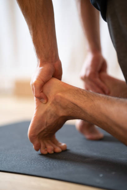 istock Vertical shot of human legs and hands doing yoga exercise 1454974536