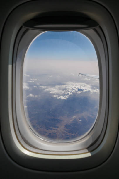 guardando attraverso l'oblò dell'aeroplano del finestrino - window porthole sky cloudscape foto e immagini stock