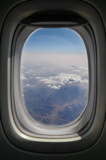 Looking Through Window Airplane Porthole Looking Through Window Airplane Porthole stratosphere airplane cloudscape mountain stock pictures, royalty-free photos & images