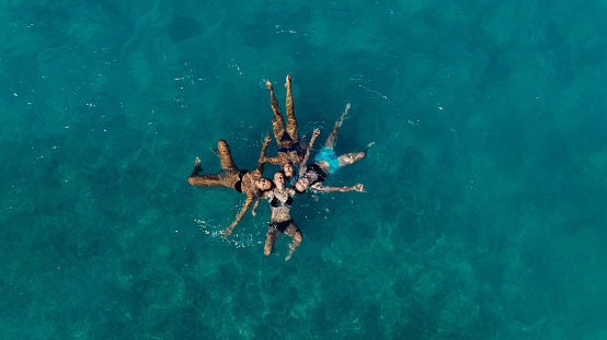 High angle view photo of a young girls swimming and relaxing in the sea, on summer vacation