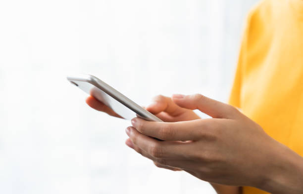 istock Hand holding smartphone with using social media on internet on sofa in living room. 1454977906