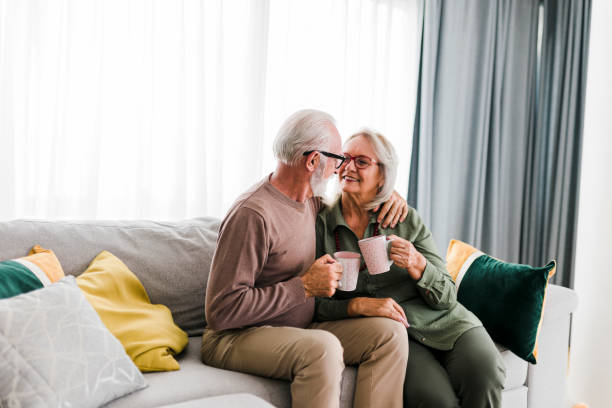 istock Senior retired couple drinking tea and enjoy talking conversation together on sofa with happiness laugh smile and joyful at home 1454978031