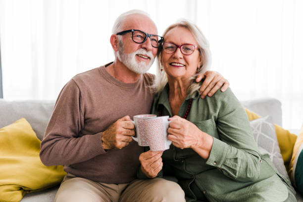 istock Senior retired couple drinking tea and enjoy talking conversation together on sofa with happiness laugh smile and joyful at home 1454978048