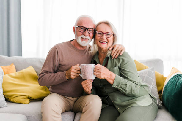 istock Senior retired couple drinking tea and enjoy talking conversation together on sofa with happiness laugh smile and joyful at home 1454978060