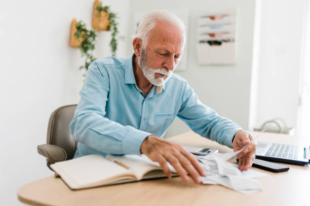 istock Senior man checking bills at home office 1454978070