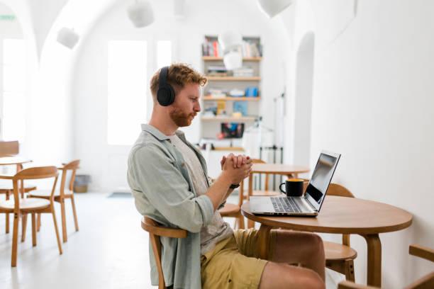 istock Ginger businessman using laptop and having video call at coffee shop 1454978816