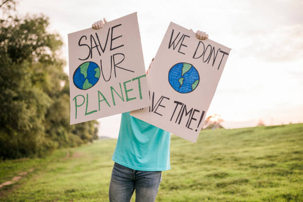 istock Man holding banner signs while going to a demonstration against climate change. Protest against global warming. Climate change protest concept. 1454978919