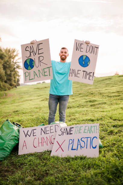 istock Man holding banner signs while going to a demonstration against climate change. Protest against global warming. Climate change protest concept. 1454979054