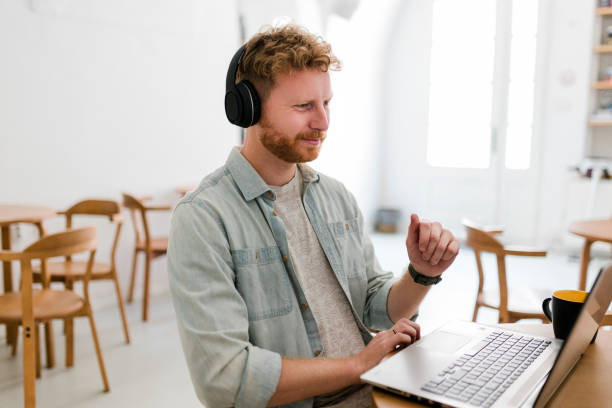 istock Ginger businessman using laptop and having video call at coffee shop 1454979101