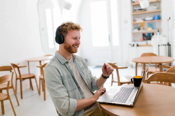 istock Ginger businessman using laptop and having video call at coffee shop 1454979131