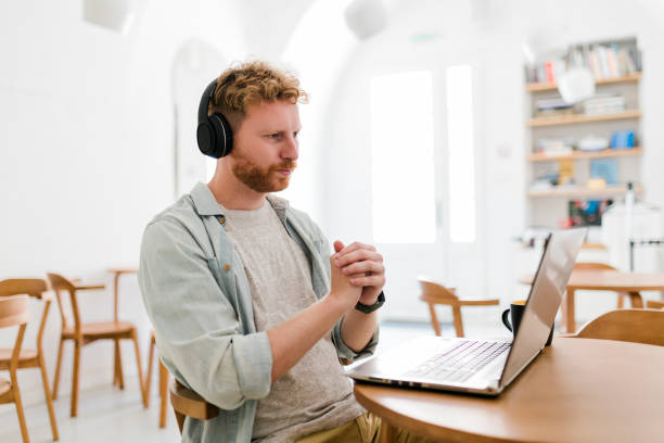 istock Ginger businessman using laptop and having video call at coffee shop 1454979146