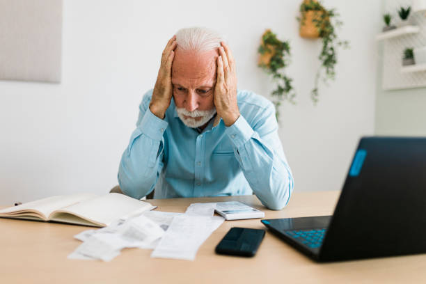 istock Senior man checking bills at home office 1454980210
