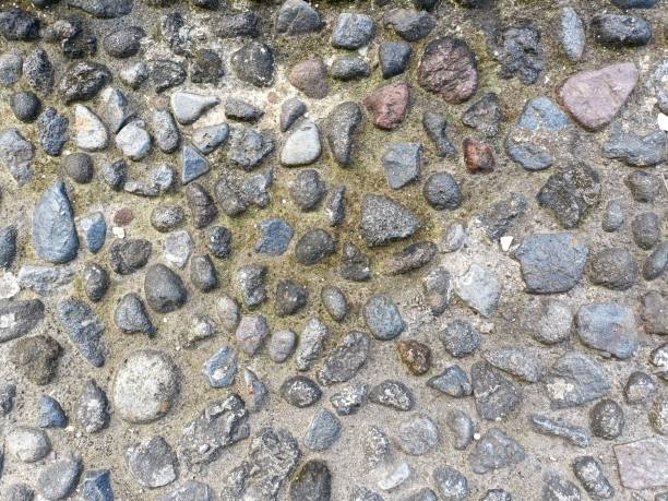 istock Rough stone pavement with coarse stones set in concrete 1454980689