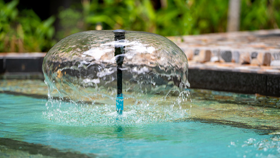 Close-up of a single water jet in a water fountain shot with a fast shutter speed creates an natural background image.