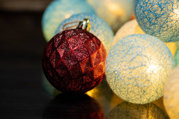 Christmas ornaments, beautiful illuminated Christmas ornaments in a low key composition, selective focus.