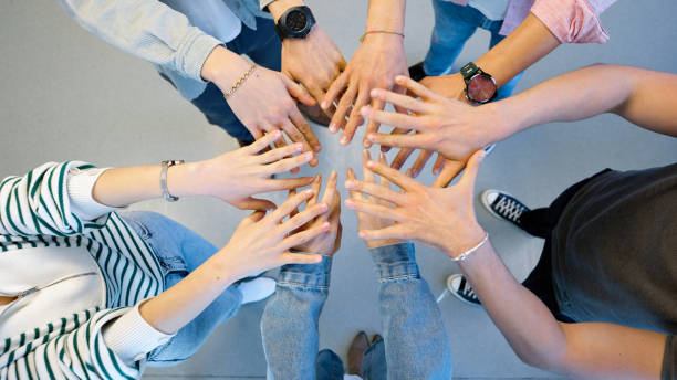 istock Coworkers joining hands in the office 1454984277