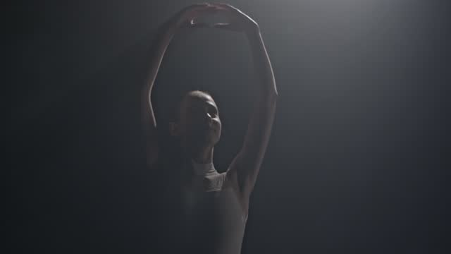 SLOW MOTION Young ballet female dancer in dress performing at studio