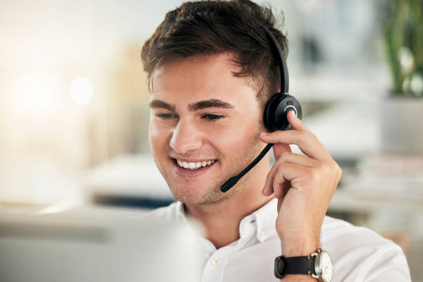 istock Headset, young man and call center for customer service, communication and sales growth. Telemarketing, male employee and consultant happy to have conversation, being helpful and talking with clients 1454986775
