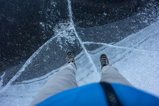 Man traveling nord, walking on icy frozen lake in the winter. Extreme travel adventures.