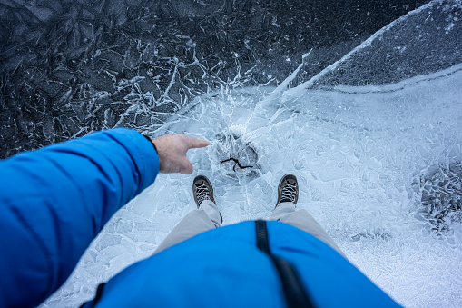 Man traveling nord, walking on icy frozen lake in the winter. Extreme travel adventures.