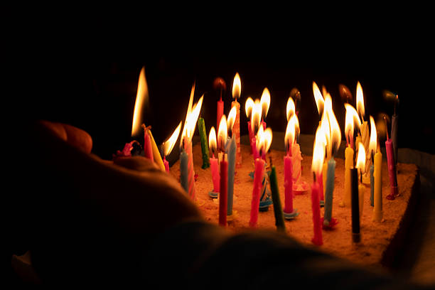 istock light multi-colored candles on a festive anniversary cake  in the dark 1454989472