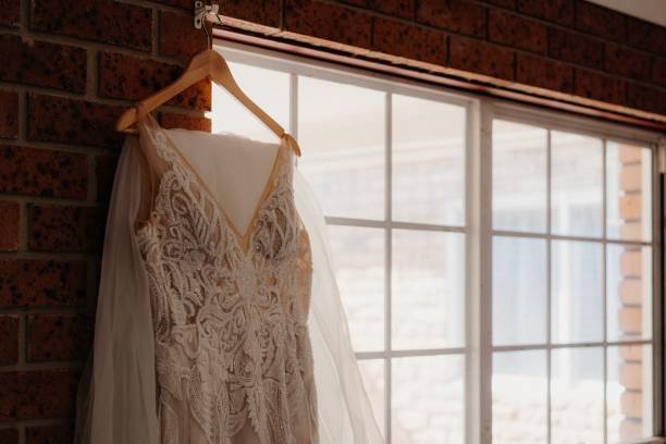 istock Selective of a bride's dress hanging in a room 1454989523