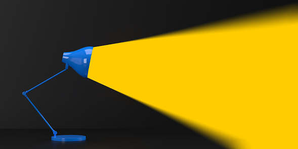 3D Spott light concept: Side view on realistic modern glowing desk lamp illumiating with yellow light beam dark background, copy space. Blank minimal business surface. Add your text message. Ray embodying the idea.
