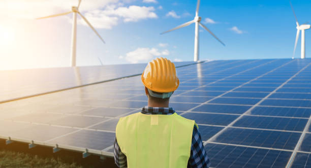 istock Engineer working for alternative energy farm - Wind turbine and solar panels 1454991142