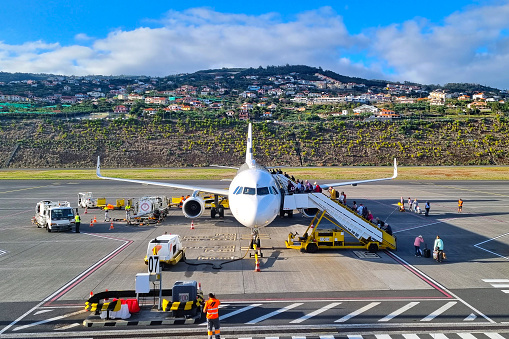 Madeira, Portugal, November 29, 2022: Passengers board a plane on Madeira Island, Portugal. Vacation on the island