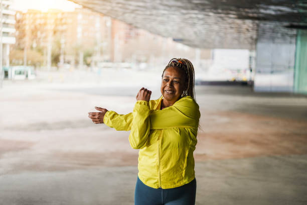 istock Senior african woman stretching during workout routine outdoor 1454991986