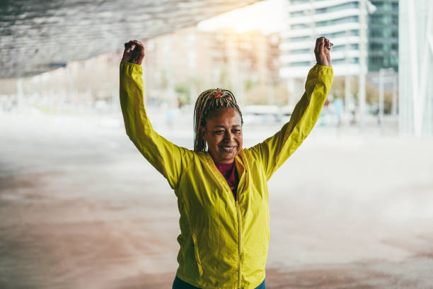 istock Senior african woman stretching during workout routine outdoor 1454991987