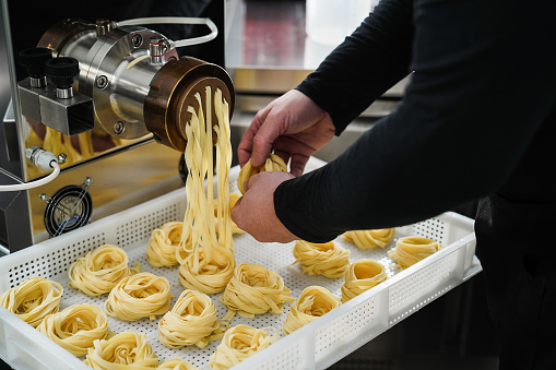 Chef working with pasta manufacture machine