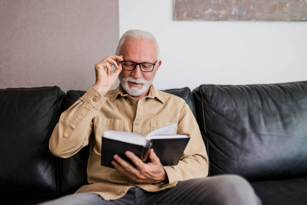 istock Senior Man reading book at home 1454993464