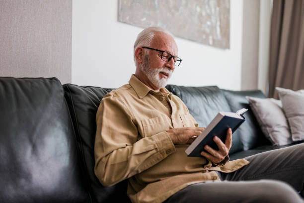 istock Senior Man reading book at home 1454995158