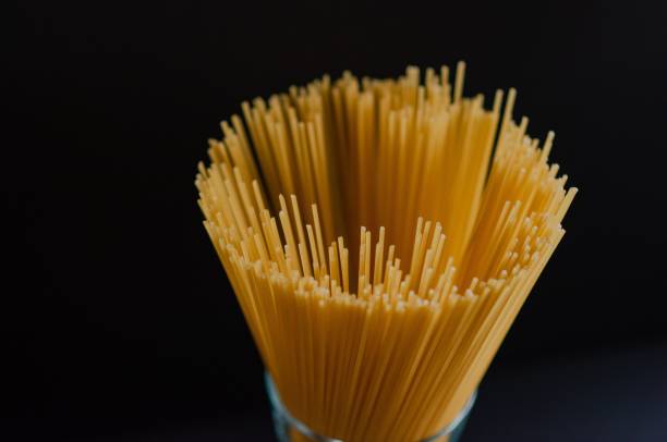 Closeup of raw pasta isolated on a black background, waiting to be cooked in a restaurant