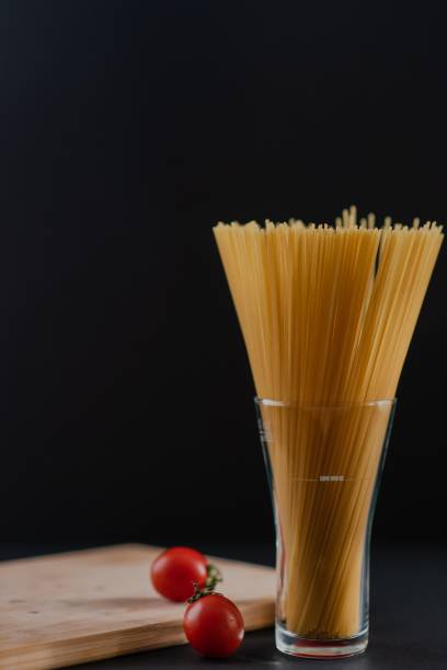 Vertical view of raw pasta ready to be cooked with cherry tomatoes