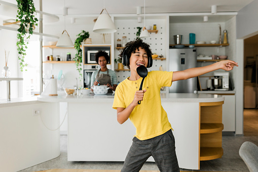 Boy having fun while his mother cooking