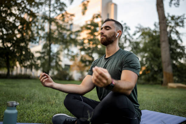 istock Young man meditating outdoors at park 1454998778