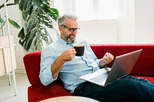istock Man drinking coffee and having video call at home office 1454999606