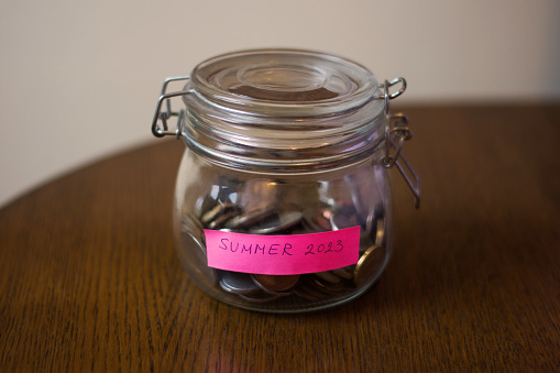 A glass jar with coins, and a paper saying 