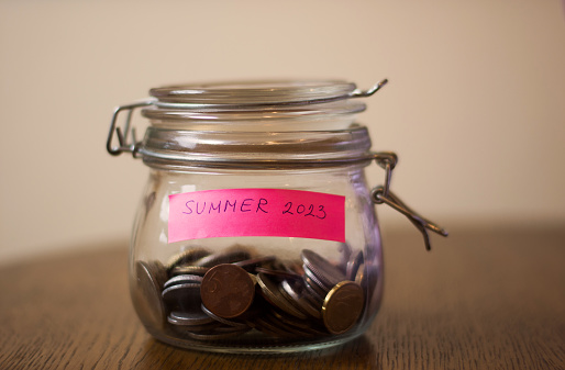 A glass jar with coins, and a paper saying 