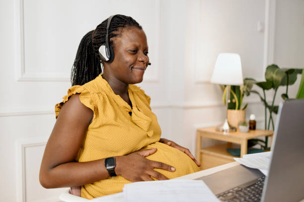 istock Pregnant woman using headset to speak with her clients 1455006749