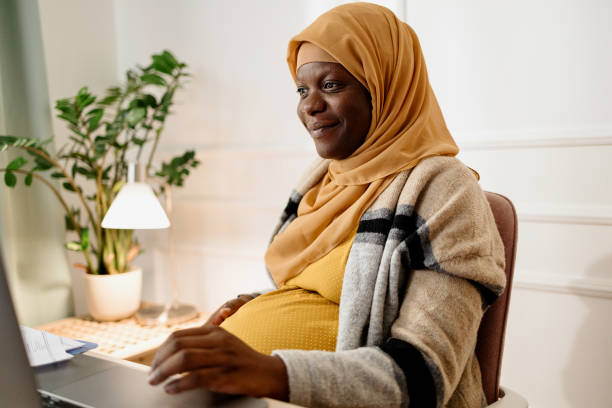 istock Pregnant  black muslim woman working from office 1455008937